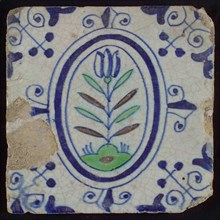 Tile, flower on ground in blue, green and brown on white, inside an oval with lilies, corner motif, wall tile tile sculpture
