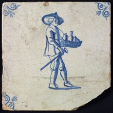 Occupation tile, blue with man with hat and leaf with bottles and walking stick in his hand, corner motif, ox-head, wall tile