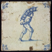Occupation tile, blue with an image of man with big package on the back, corner motif ox's head, wall tile tile sculpture
