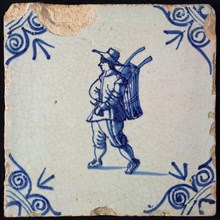 Occupation tile, blue with an image of man with hat and basket on the back, corner motif, ox-head, wall tile tile sculpture