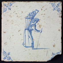Occupation tile, blue with figure of figure with skirt and basket of bread On the back, corner motif of ox's head, wall tile