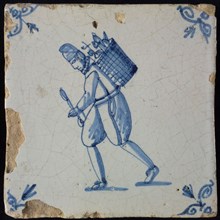 Occupation tile, blue with man with hat and basket on the back, corner motif ox's head, wall tile tile sculpture ceramic
