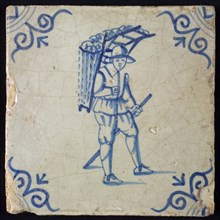 Occupation tile, blue with man with hat and basket or rack with loaves of bread On the back, corner motif ox's head, wall tile