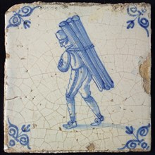 Occupation tile, blue with man with cap and round tubes or bars on the back, corner motif oxen head, wall tile tile sculpture