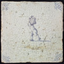 Occupation tile, blue with man crumbling with basket on the back, corner motif ox's head, wall tile tile sculpture ceramic