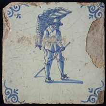 Occupation tile, blue with man with bars or tubes on the back, corner motif oxen head, wall tile tile sculpture ceramic