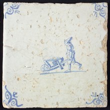 Occupation tile, blue with man behind wheelbarrow, corner motif oxen head, wall tile tile sculpture ceramic earthenware glaze
