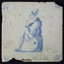 Occupation tile, blue with man sitting on barrel, corner motif ox's head, wall tile tile sculpture ceramic earthenware glaze