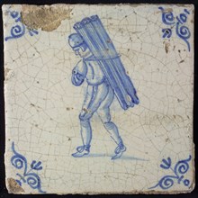 Occupation tile, blue with man carrying with beams or tubes, corner motif ox's head, wall tile tile sculpture ceramic