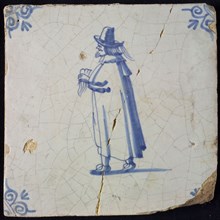 Occupation tile, blue with standing nobleman with handkerchief In hand, long cloak, top hat, corner pattern ox head, wall tile
