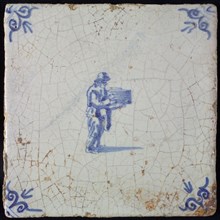 Occupation tile, blue with standing man with pile in his hands, corner motif ox's head, wall tile tile sculpture ceramic
