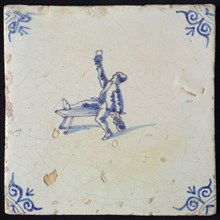 Figure tile, blue with man sitting with one leg on bench, lifting glass, another hand beer jug, corner motif oxen head, wall