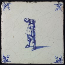 Figure tile, blue with standing man drinking from beer jug, corner motif oxen head, wall tile tile sculpture ceramic earthenware