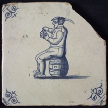 Figure tile, blue with man sitting on barrel with playing cards in hand, corner motif ox's head, wall tile tile sculpture