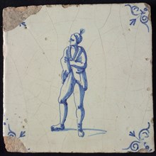 Figure tile, blue with man with bare torso and wrapped cloth around the shoulders, hat with plume, corner pattern ox-head, wall