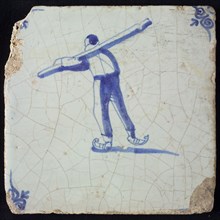 Figure tile, blue with skating man, seen from behind, the man carries long beam on the shoulder, corner motif oxen head, wall