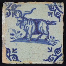 Animal tile, long-haired goat with big horns to the left on the ground, in blue on white, corner motif large ox-head, wall tile