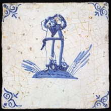 Figure tile, blue with man (sailor?) With arms up on ground with fish At his feet, corner pattern ox head, wall tile