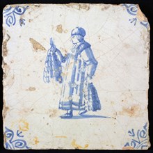 Figure tile, blue with standing man (spiritual?) With bunches with braided onions In his hands, corner pattern ox's head, wall