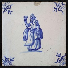 Figure tile, blue with lady with raised glass and recorded overcoat, corner motif oxen head, wall tile tile sculpture ceramic