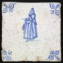 Figure tile, blue with lady with veil and millstone collar and has coil thread in the hands, corner pattern ox head, wall tile