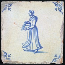 Figure tile, blue with walking and calling lady with round vase in the hands, corner pattern ox head, wall tile tile sculpture