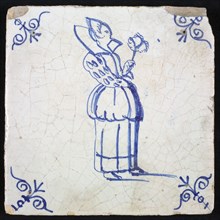 Figure tile, blue with distinguished lady with very high collar and wide sleeves and feather fan in hand, corner pattern ox head
