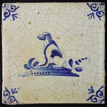 Animal tile, sitting dog to the left on plot, in blue on white, corner pattern ox head, wall tile tile sculpture ceramic
