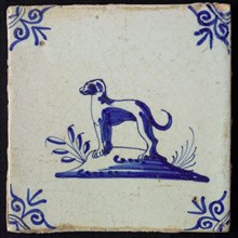 Animal tile, standing dog to the left on ground, in blue on white, corner motif oxen head, wall tile tile sculpture ceramic