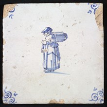 Figure tile, blue with woman with package or barrel on the back, corner motif ox's head, wall tile tile sculpture ceramic