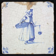 Figure tile, blue with saleswoman with basket on the hip and scale in hand, corner pattern ox head, wall tile tile sculpture