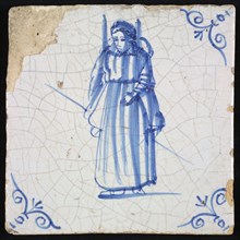 Figure tile, blue with lady with carrying frame on the back and staff in the hand, corner pattern ox head, wall tile