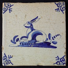 Animal tile, lying hare left on ground, in blue on white, corner pattern ox head, wall tile tile sculpture ceramic earthenware