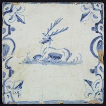Animal tile, lying deer to the left on ground between balusters, in blue on white, corner pattern French lily, wall tile