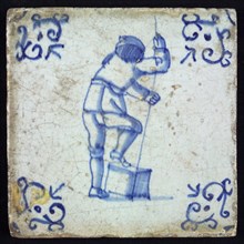 Figure tile, blue with man standing with one leg on chest with rope or stick in the hands, corner motif voluut, wall tile