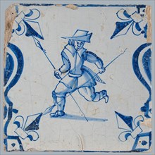 Figure tile, blue with man running with two spears, between balusters with lily, wall tile tile sculpture ceramic earthenware
