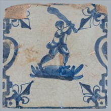 Figure tile, blue with man with bat raised above the head rabbit hunting, between balusters with lily, wall tile tile sculpture