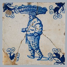 Figure tile, blue with big Bartmann jug, also called Bellarmine jug, walking with big basket with fish on the head, corner motif