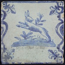 Animal tile, jumping hare to the left on plot between balusters, in blue on white, corner pattern French lily, wall tile