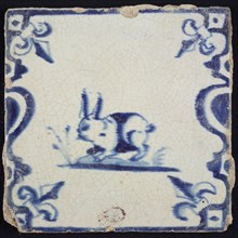 Animal tile, walking hare to the left on plot between balusters, in blue on white, corner pattern French lily, wall tile