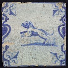 Animal tile, jumping dog to the left on plot between balusters, in blue on white, corner pattern French lily, wall tile