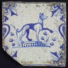 Animal tile, running dog to the right on plot between balusters, in blue on white, corner pattern French lily, wall tile