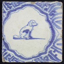 Animal tile, sitting dog to the right inside scalloped frame with braces, in blue on white, corner motif meanders, wall tile