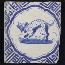 Animal tile, barking dotted dog to the left on plot within scalloped frame, in blue on white, corner pattern meanders, wall tile