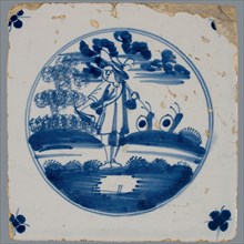 Scene tile, blue with scene design with man with hunting horn and staff, in circle frame with corner motif spider, wall tile