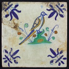 Animal tile, bird on ground in orange, brown, yellow, green and blue on white, corner pattern french lily, wall tile