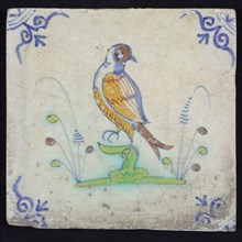 Animal tile, bird on branch to the left in orange, green, brown and blue on white, corner pattern ossenkop, wall tile