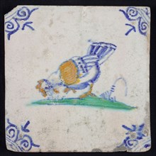 Animal tile, bird on ground to the left in orange, green and blue on white, corner motif oxen head, wall tile tile sculpture