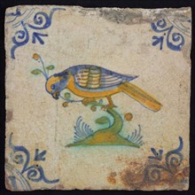 Animal tile, bird on branch to the left in orange, green and blue on white, corner pattern ossenkop, wall tile tile sculpture
