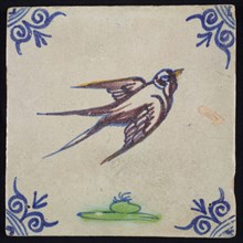 Animal tile, flying bird to the right above ground in orange, purple, green and blue on white, corner pattern ox head, wall tile